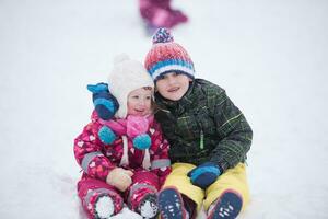 kindergruppe, die spaß hat und zusammen im frischen schnee spielt foto