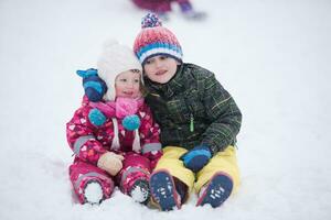 kindergruppe, die spaß hat und zusammen im frischen schnee spielt foto