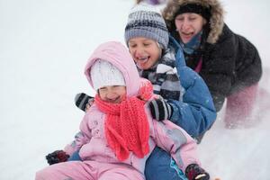 kindergruppe, die spaß hat und zusammen im frischen schnee spielt foto