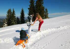 familie, die spaß auf frischem schnee im winter hat foto