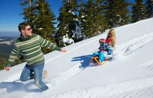 familie, die spaß auf frischem schnee im winter hat foto