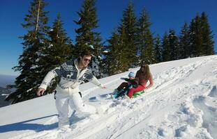 familie, die spaß auf frischem schnee im winter hat foto