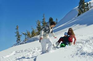 familie, die spaß auf frischem schnee im winterurlaub hat foto