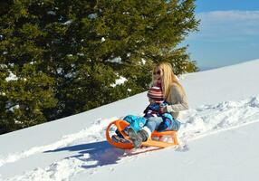 familie, die spaß auf frischem schnee im winter hat foto