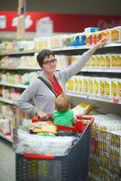 Mutter mit Baby beim Einkaufen foto