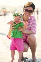 Mama und Baby am Strand haben Spaß foto