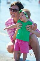 Mama und Baby am Strand haben Spaß foto