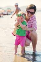 Mama und Baby am Strand haben Spaß foto