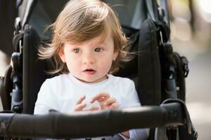 Babymädchen, das im Kinderwagen sitzt foto