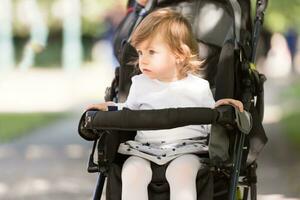 Babymädchen, das im Kinderwagen sitzt foto