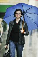 Frau auf der Straße mit Regenschirm foto