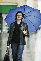 Frau auf der Straße mit Regenschirm foto