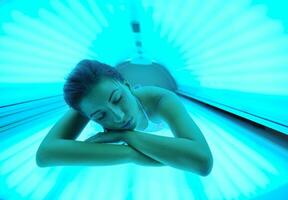 schöne junge Frau im Solarium bräunen foto