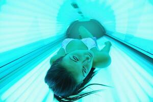 schöne junge Frau im Solarium bräunen foto