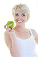 glückliche junge Frau isst grünen Apfel, isoliert auf weiss foto
