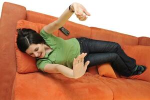 glückliche junge frau entspannen auf orange sofa foto