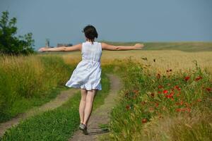 junge Frau im Weizenfeld im Sommer foto