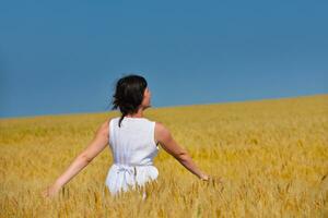 junge Frau im Weizenfeld im Sommer foto