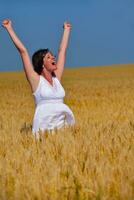 junge Frau im Weizenfeld im Sommer foto