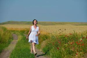 junge Frau im Weizenfeld im Sommer foto