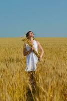 junge Frau im Weizenfeld im Sommer foto