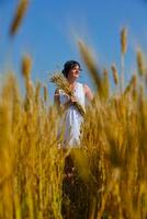 junge Frau im Weizenfeld im Sommer foto