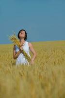 junge Frau im Weizenfeld im Sommer foto