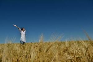 junge Frau im Weizenfeld im Sommer foto