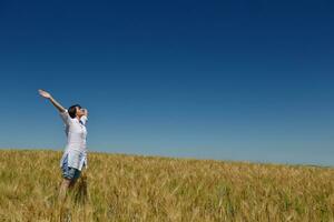 junge Frau im Weizenfeld im Sommer foto