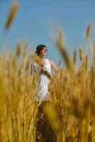 junge Frau im Weizenfeld im Sommer foto