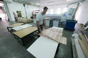 Arbeiter in einer Holzmöbelfabrik foto