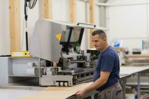 Arbeiter in einer Holzmöbelfabrik foto