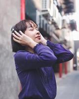 glückliche junge asiatische frau, die musik hört foto