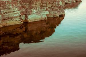 Cliff im ein alt Steinbruch mit Betrachtung im das Wasser. Kalkstein Schichten sind sichtbar. getönt Bild. foto