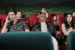 verschiedene Menschen im Theater. gemischtrassig Publikum, schwarz Frau, und freunde Aufpassen dramatisch Kino und traurig emotional Ausdrücke zusammen auf Film zeigt an Ende, Unterhaltung Lebensstil mit Film. foto