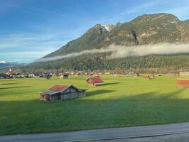 Dorf im Österreich mit Berge im das Hintergrund umgeben durch ein Meer von Nebel. foto