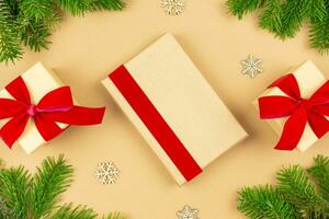 Weihnachten eingewickelt Jahrgang Geschenk Box Attrappe, Lehrmodell, Simulation mit rot Band, Dekoration und Weihnachten Baum Geäst auf Papier Hintergrund. Urlaub eben legen Vorlage. oben Sicht. foto