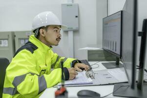 elektroingenieurmann, der die spannung am stromverteilerschrank im kontrollraum überprüft, jährliche vorbeugende wartung, thailand-elektriker, der im unternehmen arbeitet foto