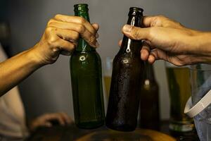 Hände halt von Klirren Bier Flaschen foto