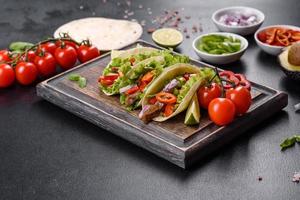 mexikanische Tacos mit Rindfleisch, Tomaten, Avocado, Zwiebeln und Salsasauce