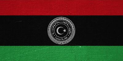 Flagge und Mantel von Waffen von Zustand von Libyen auf ein texturiert Hintergrund. Konzept Collage. foto