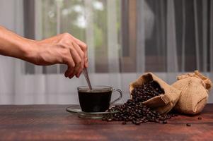 Hand, die Kaffeegetränk für Energie macht foto