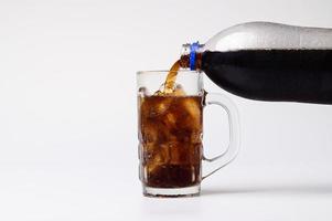 Cola im Glas mit klaren Eiswürfeln auf weißem Hintergrund foto