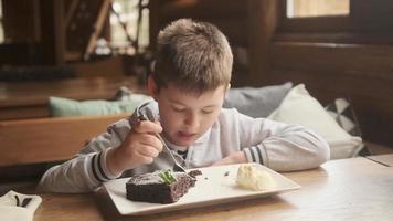 Junge isst einen Brownie foto