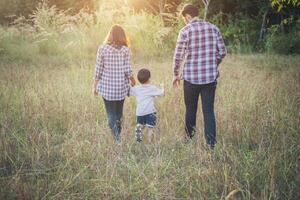 Rückseite der jungen Familie, die gute Zeit zusammen verbringt. Familie im Freien. foto