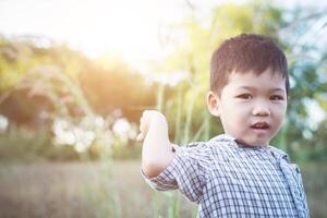 Nahaufnahme eines süßen asiatischen Jungen, der im Freien spielt und lächelt. foto