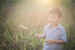 glücklicher kleiner asiatischer Junge, der draußen spielt. süßer Asiate. Junge auf dem Feld. foto