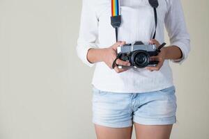 schöne junge Frau Fotografin hält Retro-Kamera foto