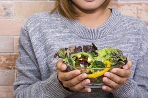 schöne Frau mit einer Schüssel frischen Gemüsesalat foto