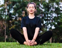 Frau meditiert und praktiziert Yoga im Wald foto